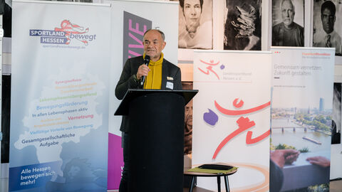 Grußwort von Roland Frischkorn, Vorsitzender des Sportkreis Frankfurt am Main e. V. Roland Frischkorn (Sportkreis Frankfurt am Main e. V.) hinter dem Rednerpult während seines Grußwortes