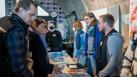 Austauschbörse verschiedener Aussteller mit Angeboten für Bewegungsförderung im öffentlichen Raum Seitenansicht der gut besuchten Austauschbörse verschiedener Aussteller mit Angeboten für Bewegungsförderung im öffentlichen Raum.