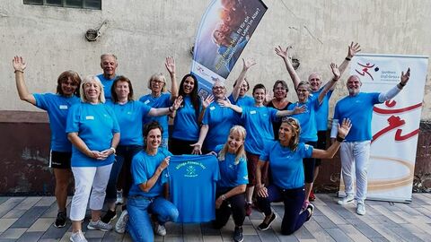 Gruppenbild von Menschen in blauen Shirts. Alle freuen sich. 