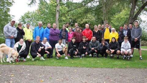 32 Teilnehmende setzen ein Zeichen für Inklusion in Korbach. Gruppe von Menschen in Sportklamotten posieren für ein Gruppenbild im Grünen.