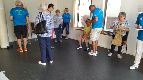 Seniorinnen und Senioren machen Übungen, Testhelfer unterstützen sie