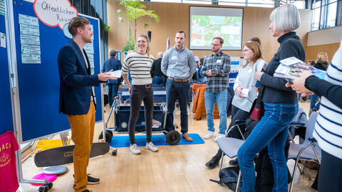 Lebensweltexpertin Linda Obermeyer (ISA - Internationales Stadtbauatelier) und Lebensweltmoderation Marco Mattes (lsb h) im Austausch mit den Teilnehmenden (Leenswelt: Öffentlicher Raum) Mehrere Personen diskutieren an Pinnwand