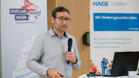 Prof. Dr. Jens Bucksch (Pädagogische Hochschule Heidelberg) bei seinem Fachvortrag zur Gestaltung einer bewegungsfreundlichen Kommune Mann mit Handmikrofon spricht