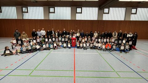 Gruppenbild mit Kindern und Erwachsenen in der Schulsporthalle