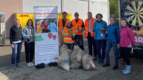 Gruppenfoto mit Menschen in Warnwesten vor einem Gebäude