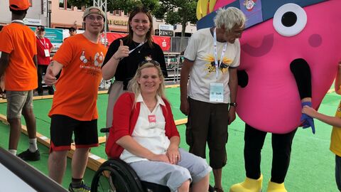 Gruppenbild mit vier Personen und Maskottchen