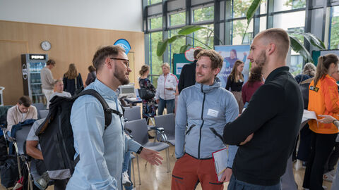 Teilnehmende tauschen sich zwischen den Ständen auf dem Markt der Möglichkeiten aus.