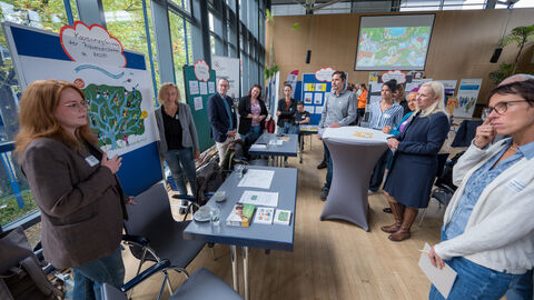 Teilnehmende tauschen sich zwischen den Ständen auf dem Markt der Möglichkeiten aus.
