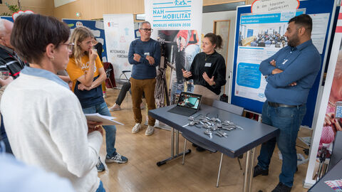 Teilnehmende tauschen sich zwischen den Ständen auf dem Markt der Möglichkeiten aus.