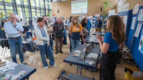 Teilnehmende tauschen sich zwischen den Ständen auf dem Markt der Möglichkeiten aus.