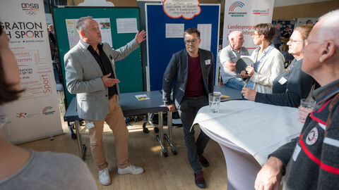 Teilnehmende tauschen sich zwischen den Ständen auf dem Markt der Möglichkeiten aus.