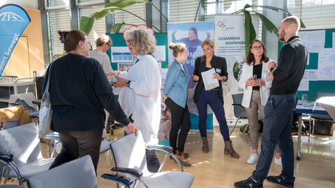 Teilnehmende tauschen sich zwischen den Ständen auf dem Markt der Möglichkeiten aus.
