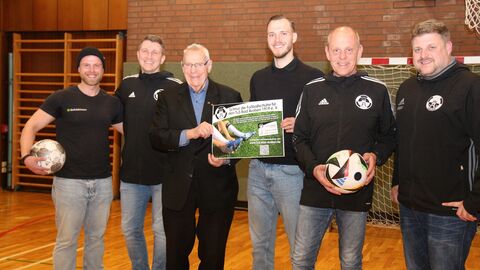 Gruppenbild mit sechs Männern in Sporthalle Gemeinsames Engagement für die inklusive Fußballmannschaft