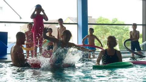 Sprünge ins Hallenbecken in Waldeck-Frankenberg Kinder springen im Hallenbad vom Beckenrand.