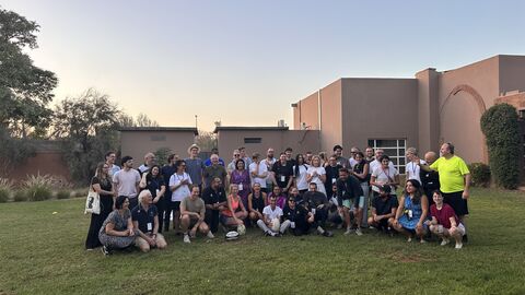 Gruppenbild mit vielen Personen bei gutem Wetter auf grüner Wiese